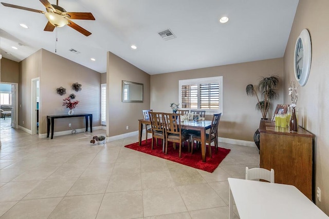 tiled dining room with ceiling fan and vaulted ceiling