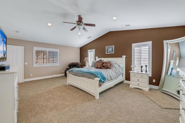 bedroom with ceiling fan, light carpet, vaulted ceiling, and multiple windows