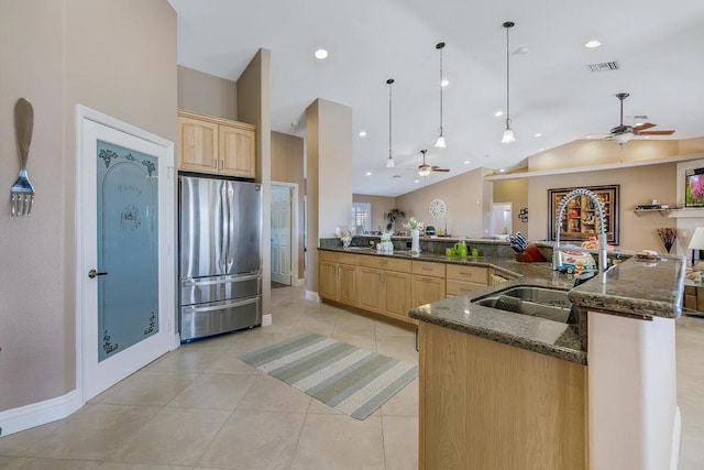 kitchen with ceiling fan, hanging light fixtures, stainless steel fridge, and light brown cabinets