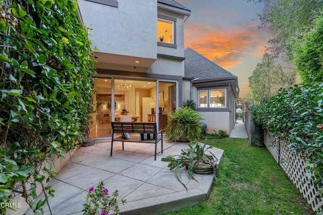 back house at dusk with a patio area