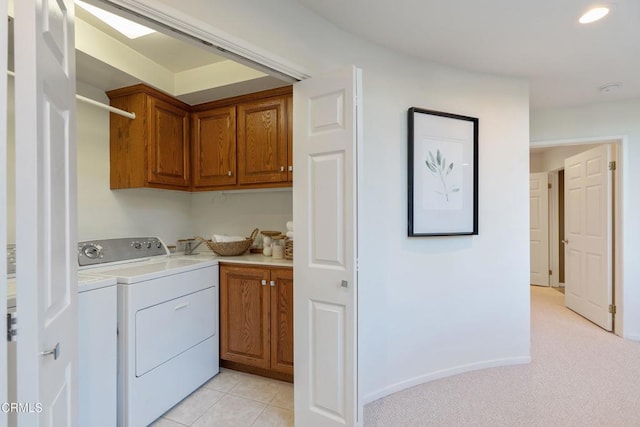 laundry area with independent washer and dryer, cabinets, and light colored carpet