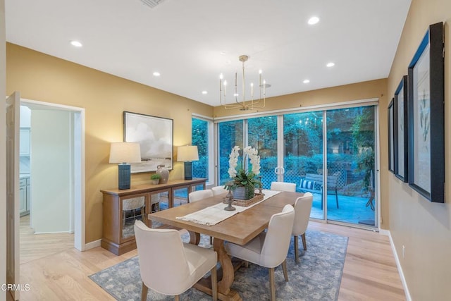 dining area with a notable chandelier and light wood-type flooring