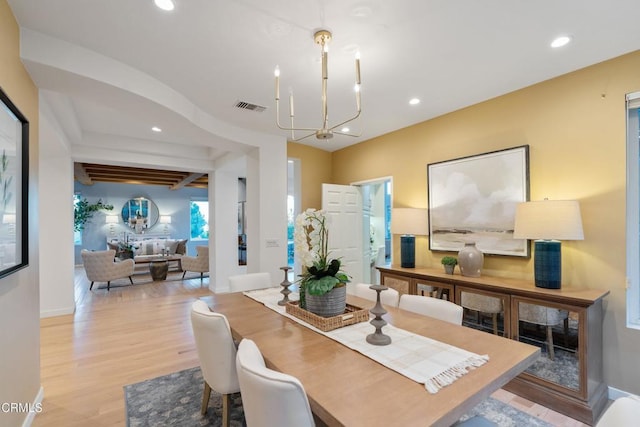 dining room with light hardwood / wood-style floors and an inviting chandelier