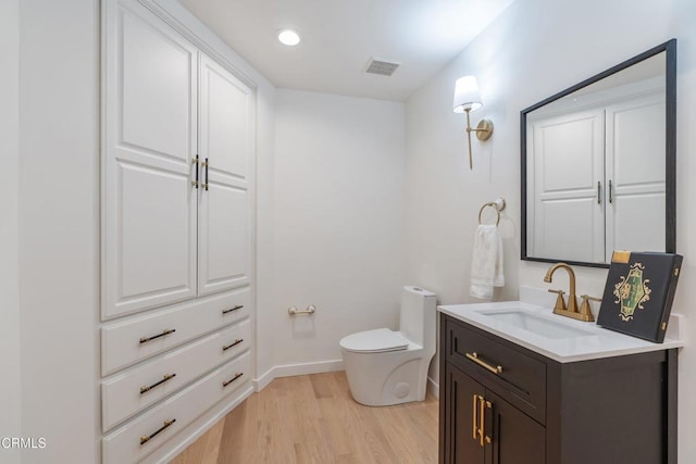 bathroom featuring vanity, hardwood / wood-style flooring, and toilet