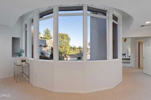 interior space featuring light carpet and vaulted ceiling