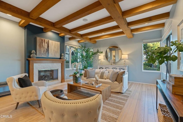 living room with beam ceiling, light hardwood / wood-style floors, and plenty of natural light