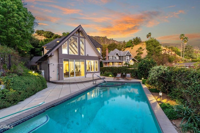 pool at dusk featuring a mountain view