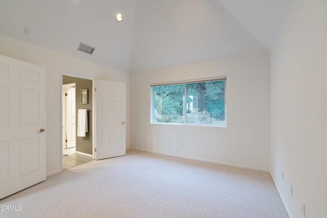 unfurnished bedroom with light carpet and vaulted ceiling