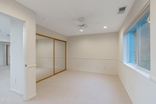 unfurnished bedroom featuring ceiling fan, a closet, and light colored carpet