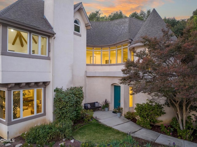 back house at dusk with a balcony