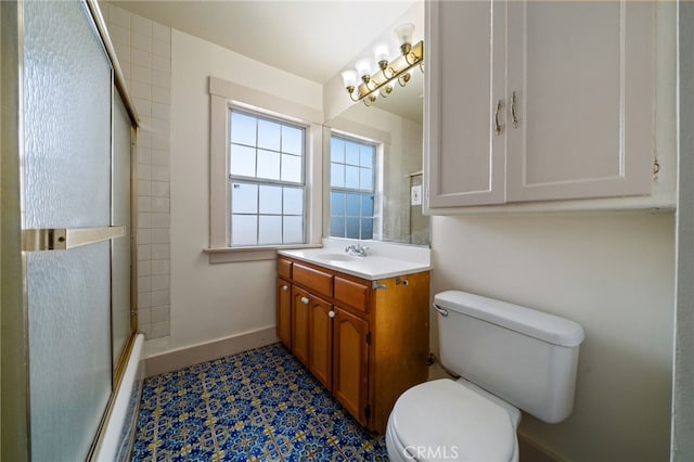 bathroom featuring toilet, vanity, and a shower with door