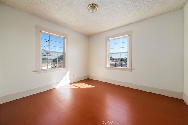 spare room with a textured ceiling and hardwood / wood-style flooring