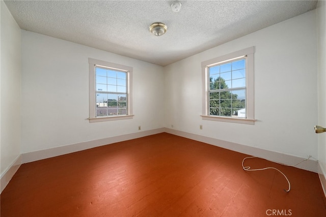 spare room with a textured ceiling and hardwood / wood-style floors