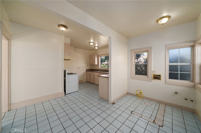 kitchen featuring light tile patterned flooring, light brown cabinets, and white range with gas cooktop