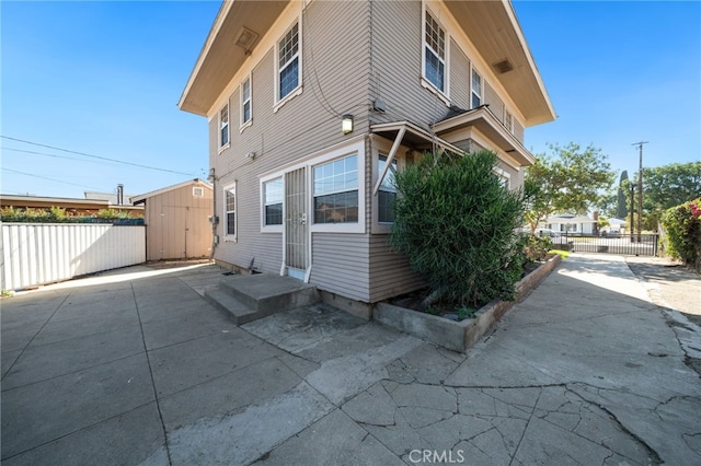 back of property featuring a patio area and a storage unit