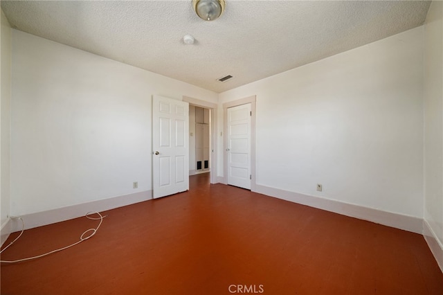 unfurnished room with a textured ceiling