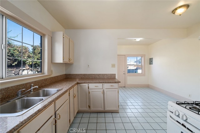 kitchen featuring light tile patterned floors, sink, and white range with gas cooktop