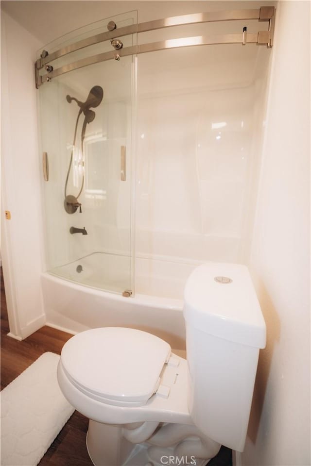 bathroom featuring hardwood / wood-style floors, shower / bathtub combination, and toilet