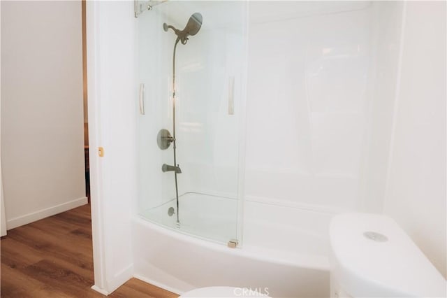 bathroom with enclosed tub / shower combo, wood-type flooring, and toilet