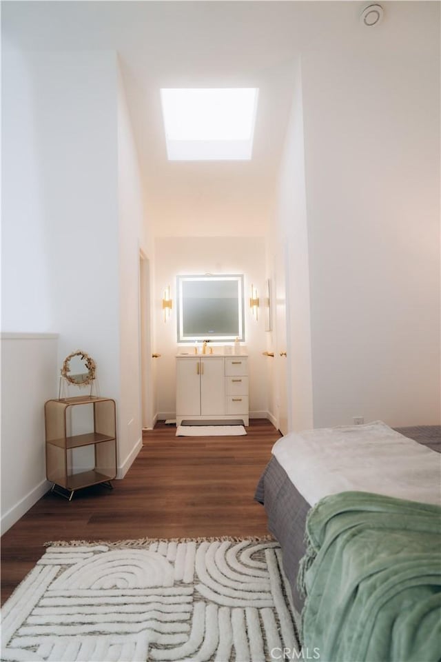 bedroom featuring dark wood-type flooring and a skylight