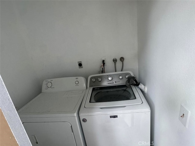 clothes washing area featuring independent washer and dryer