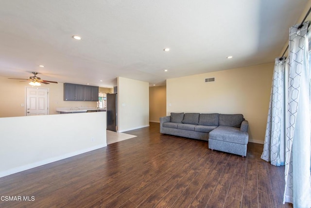 living room with ceiling fan and dark hardwood / wood-style flooring