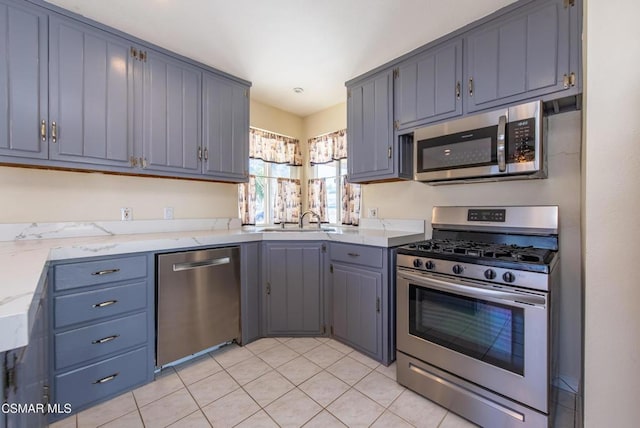 kitchen with light tile patterned floors, stainless steel appliances, and sink