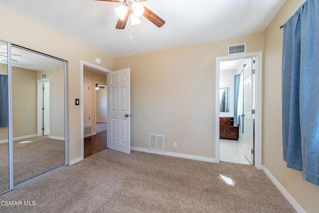 unfurnished bedroom featuring ceiling fan, a closet, and light carpet