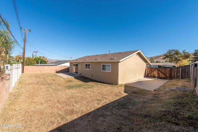 back of property featuring a yard and a patio