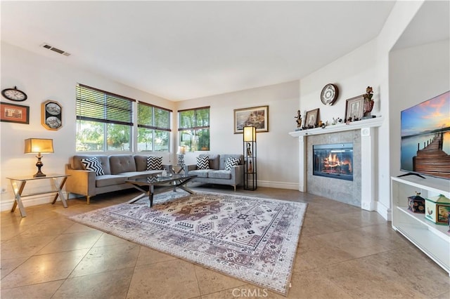 living room with a tile fireplace and light tile patterned floors