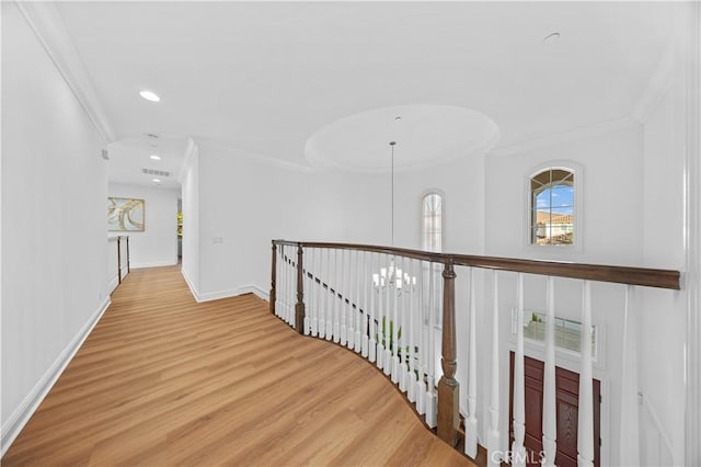 corridor with crown molding, hardwood / wood-style floors, and an inviting chandelier