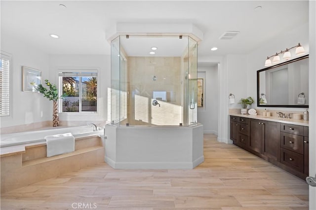 bathroom with vanity, hardwood / wood-style floors, and plus walk in shower