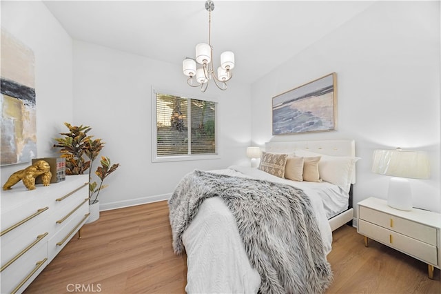 bedroom featuring a notable chandelier and light hardwood / wood-style flooring