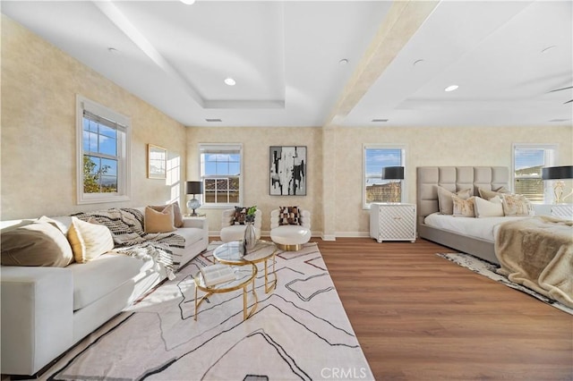 bedroom with hardwood / wood-style floors and a tray ceiling