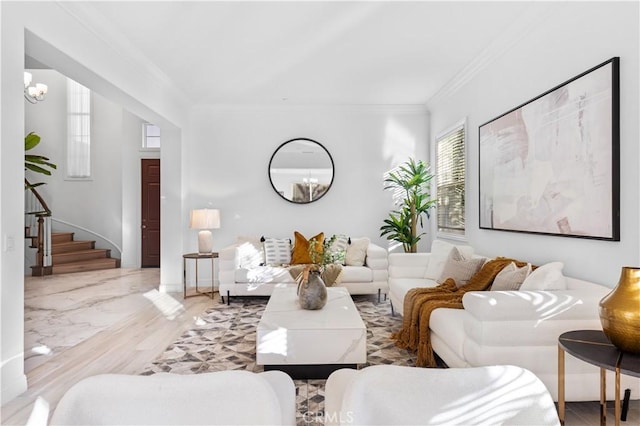 living room featuring a notable chandelier, light hardwood / wood-style floors, and crown molding