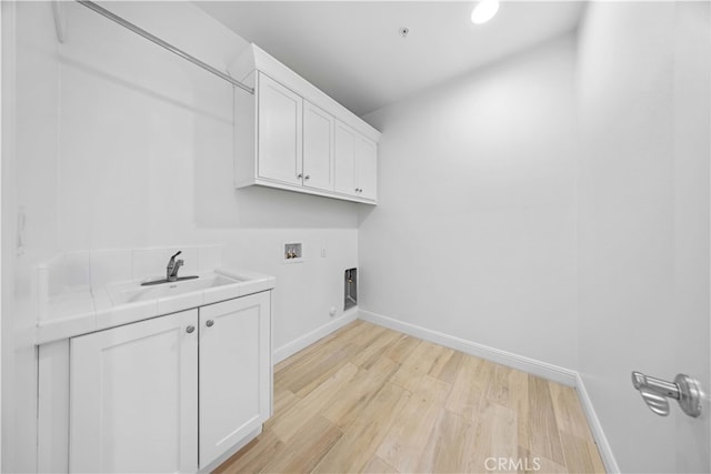 washroom with cabinets, washer hookup, electric dryer hookup, sink, and light hardwood / wood-style floors