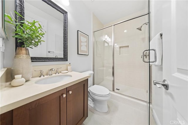 bathroom with tile patterned flooring, vanity, an enclosed shower, and toilet