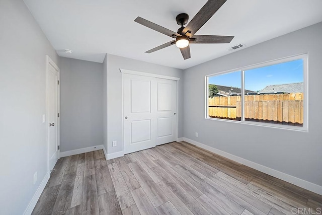 unfurnished bedroom with ceiling fan, a closet, and light hardwood / wood-style flooring