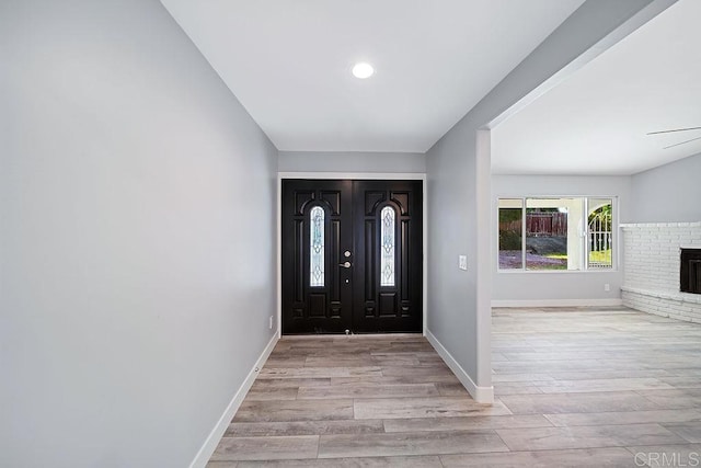 foyer featuring a fireplace and light wood-type flooring