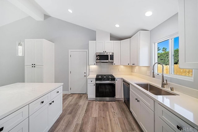 kitchen with light hardwood / wood-style floors, white cabinetry, sink, and appliances with stainless steel finishes