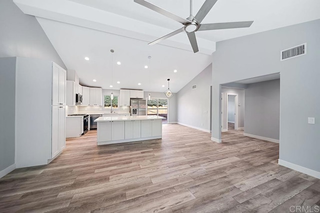 kitchen with appliances with stainless steel finishes, light wood-type flooring, decorative light fixtures, white cabinets, and a kitchen island