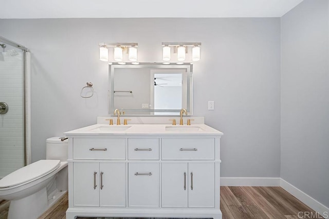 bathroom featuring vanity, a shower with door, ceiling fan, hardwood / wood-style floors, and toilet