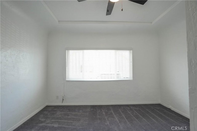 spare room featuring ceiling fan, a healthy amount of sunlight, and dark carpet