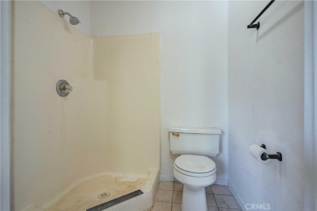 bathroom featuring tile patterned floors, a shower, and toilet