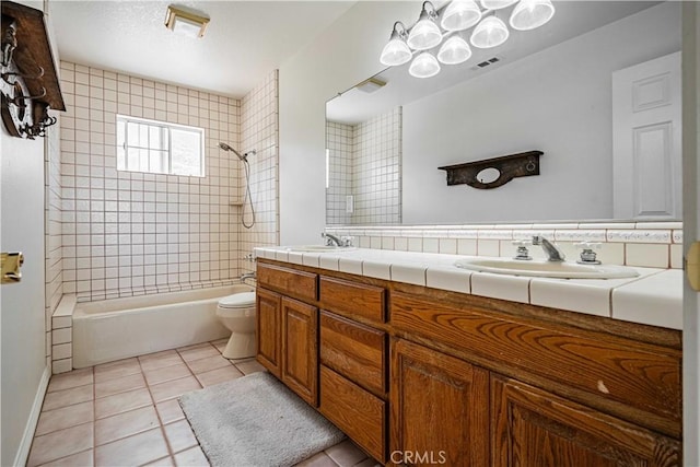 full bathroom with tiled shower / bath combo, tile patterned floors, toilet, decorative backsplash, and vanity