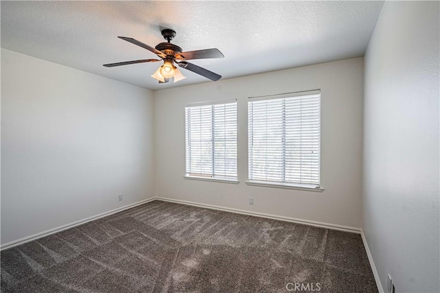 empty room with dark colored carpet, ceiling fan, and a textured ceiling