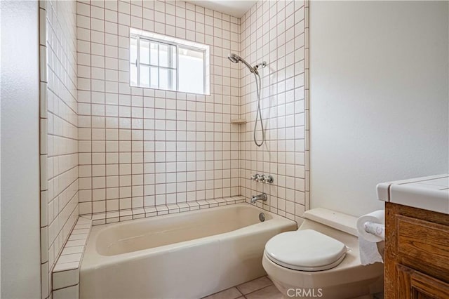 full bathroom with vanity, tile patterned flooring, tiled shower / bath, and toilet