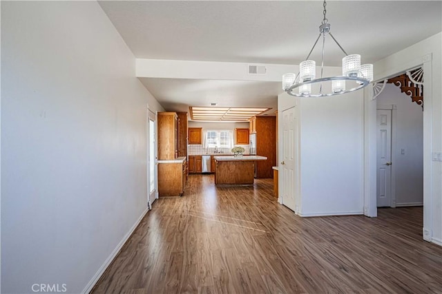 kitchen featuring dishwasher, backsplash, dark hardwood / wood-style floors, decorative light fixtures, and a chandelier