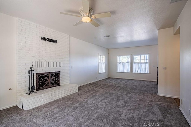 unfurnished living room featuring dark colored carpet, a textured ceiling, a brick fireplace, and ceiling fan