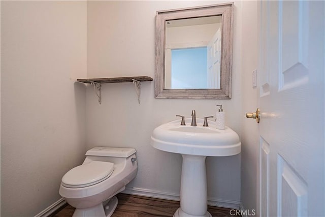 bathroom featuring hardwood / wood-style floors and toilet